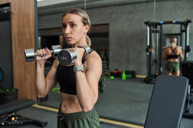 Woman exercising with dumbbells in gym