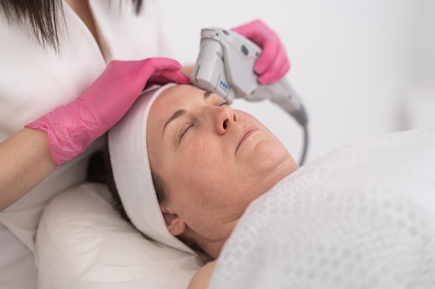 A woman face close up receiving a facial laser treatment to enhance her skin texture and tone