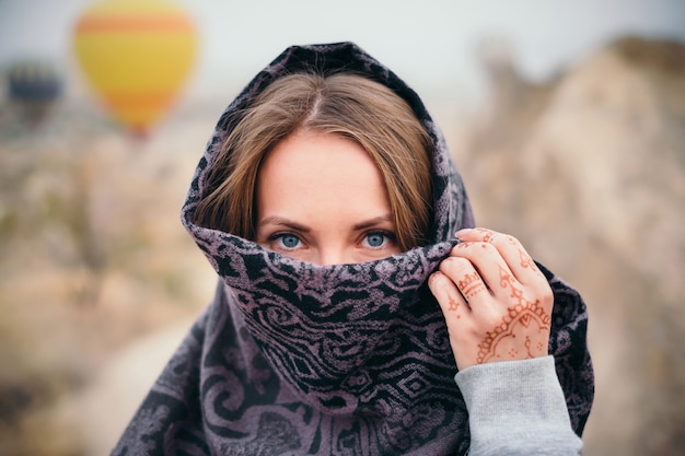 Photo woman face covered with scarf and mehendi tattoo on hand