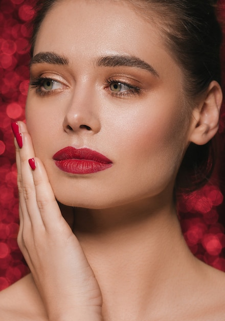 Woman face party beauty red lipstick clean skin beautiful female glamour. Red sequins background