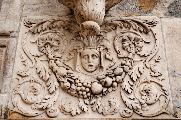 Woman face with floral patterns on the stone slab of the duomo facade milan italy