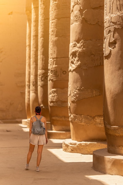 Woman facing the columns of an egyptian temple