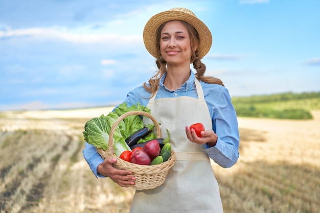 Woman farmer straw hat apron standing farmland smiling