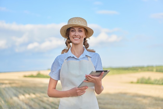 Woman farmer straw hat smart farming standing farmland smiling using digital tablet Female agronomist specialist research monitoring analysis data agribusiness