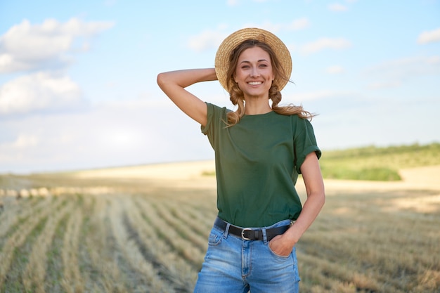 Woman farmer straw hat standing farmland smiling