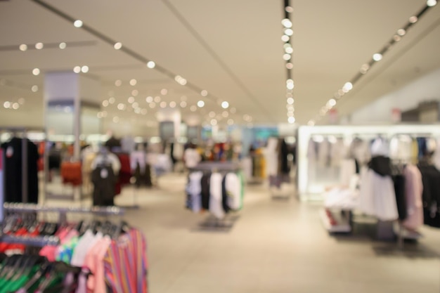 Woman fashionable boutique clothing store window display in shopping mall blur defocused background