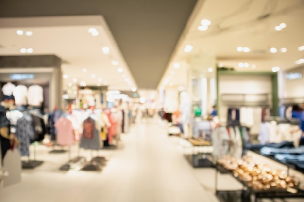 Woman fashionable boutique clothing store window display in shopping mall blur defocused background