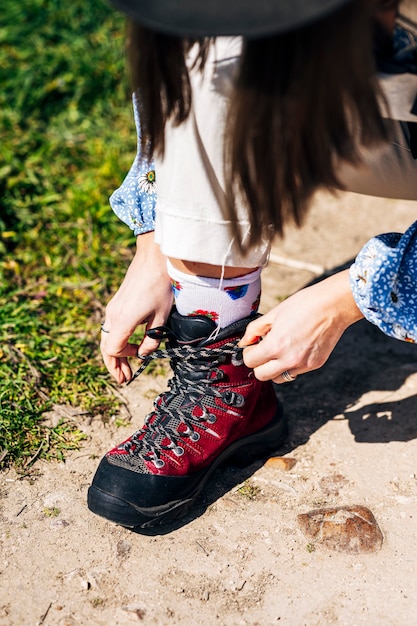 Woman fastening the laces of her hiking boots