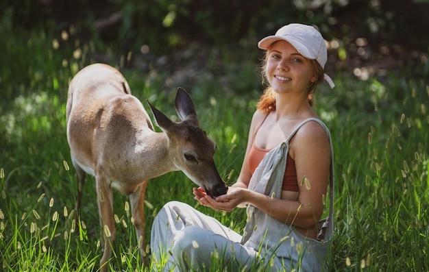 Woman feed deer Wild animals concept Woman feeding fawn Animal at park