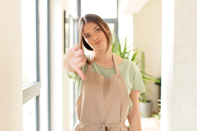 woman feeling cross, angry, annoyed, disappointed or displeased, showing thumbs down with a serious look