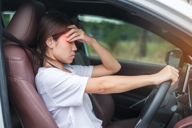 Woman feeling stress and angry during drive car long time Asian girl tired and fatigue having headache stop after driving car in traffic jam Sleepy stretching and drunk concept