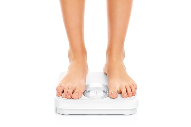 woman feet on bathroom scales on white background