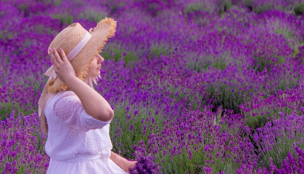 Woman in a field of lavender flowers in a white dress Ukraine