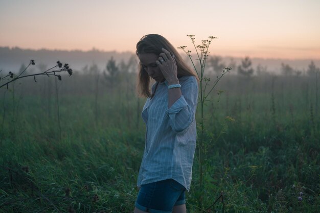 Photo woman in a field with misty fog