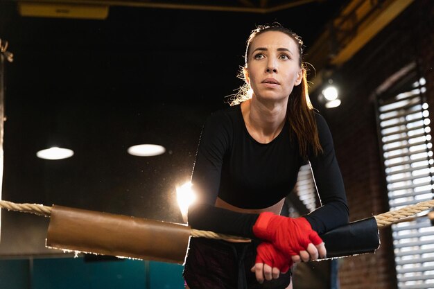 Woman fighter girl power woman fighter with red boxing wraps protective bandages standing on boxing