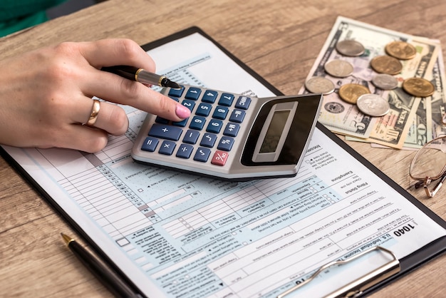 Woman filling tax form with money and calculator