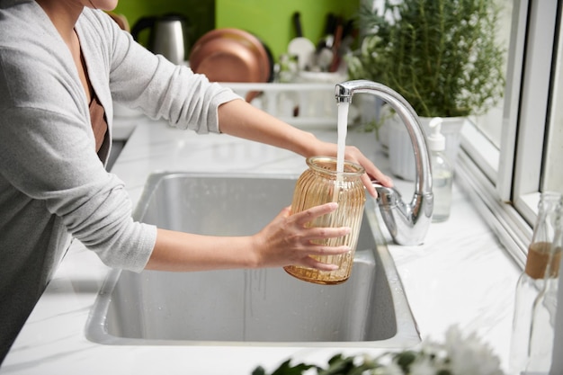 Woman Filling Vase with Water