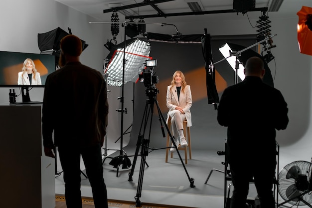 A woman at film studio set behind the scenes the room is filled with visual arts equipment setting