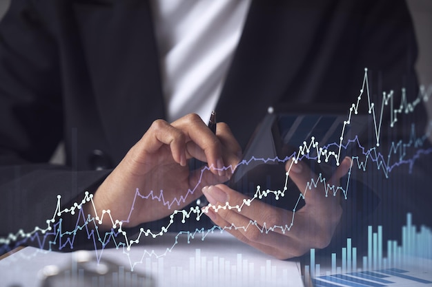 A woman financial trader in formal wear is checking the phone to sign the contract to invest money in stock market Internet trading and wealth management concept Forex hologram chart