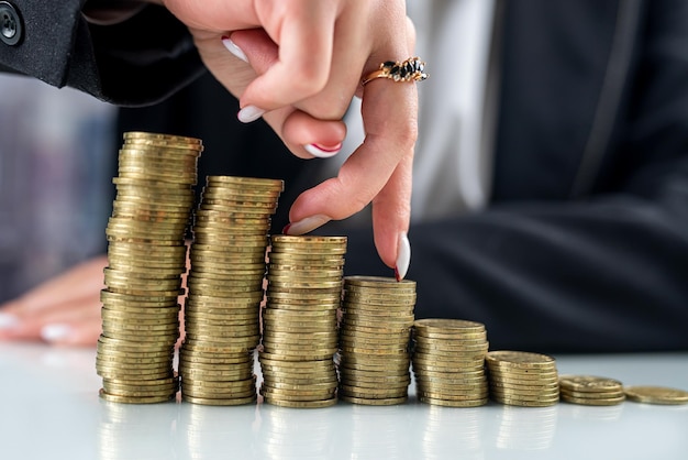 Woman finger up the rating chart of coins on the glass office table