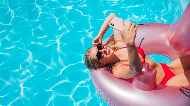 Woman in flamingo swim ring with copy space