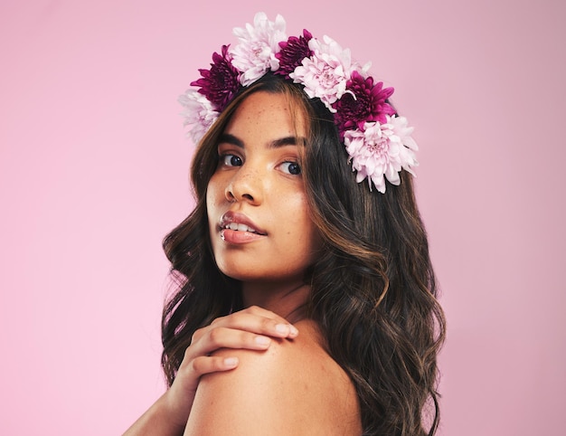 Woman flower crown and portrait in studio for beauty natural skincare and spring plants on pink background Face model and floral wreath for sustainability eco dermatology and hair care cosmetics