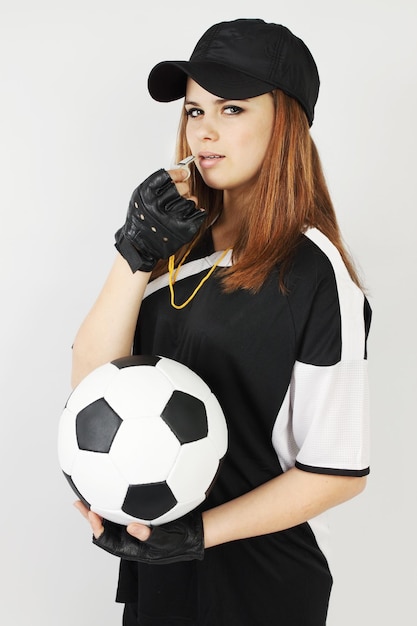 Woman football coach holds ball and whistle