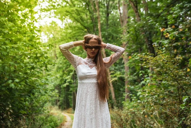 Photo a woman in the forest covering her eyes with her hair