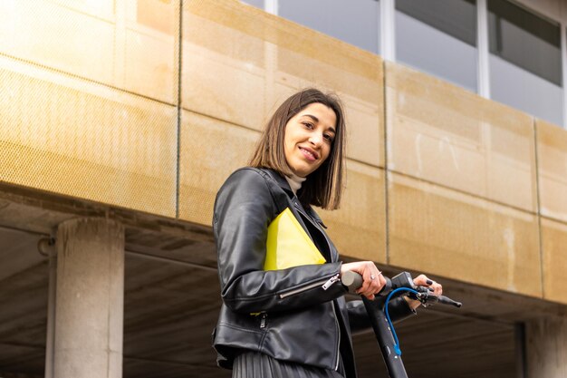 Woman in formal wear with an electric scooter Young woman in an electric scooter looking at the camera