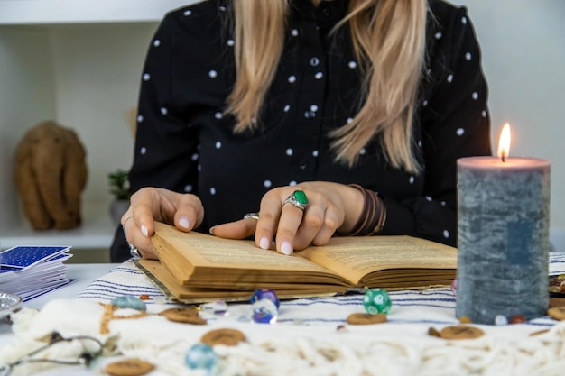 Woman fortune teller reads a book of spells Selective focus