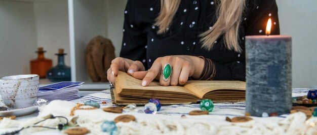 Woman fortune teller reads a book of spells Selective focus