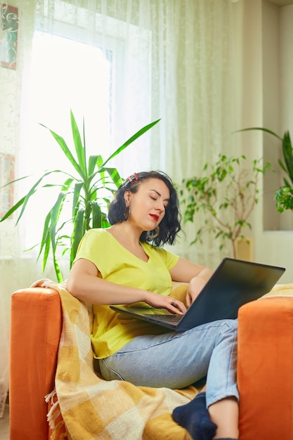 Woman freelancer working on laptop at home