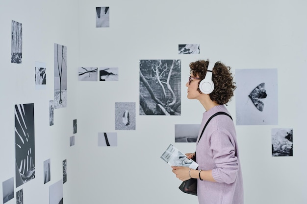 Woman at gallery listening to guide