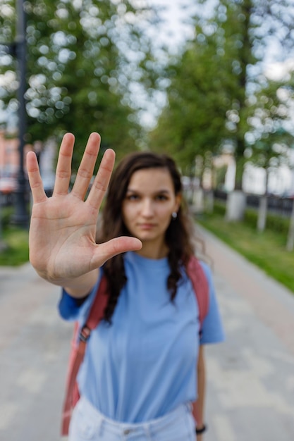 Woman gesturing stop with hand outstretched forward Street female portrait