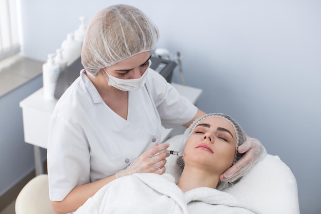 Woman gets injection in her face Beauty woman giving botox injections