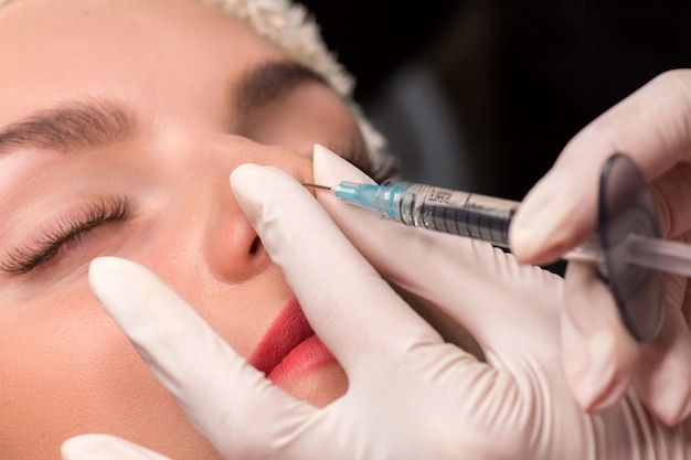 Woman getting cosmetic injection of botulinum to nose