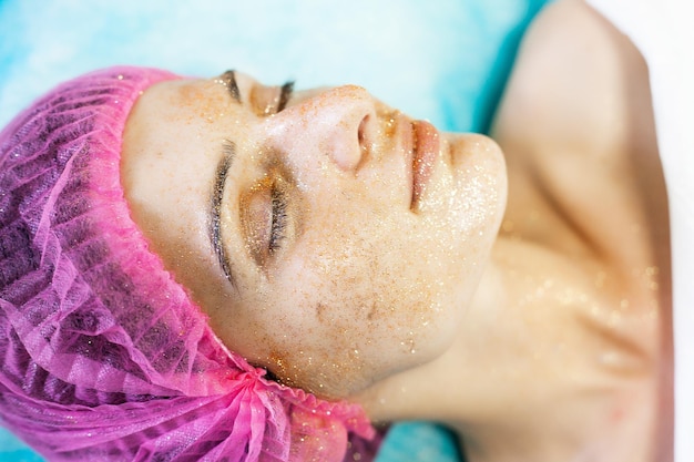 Woman getting facial care in spa salon