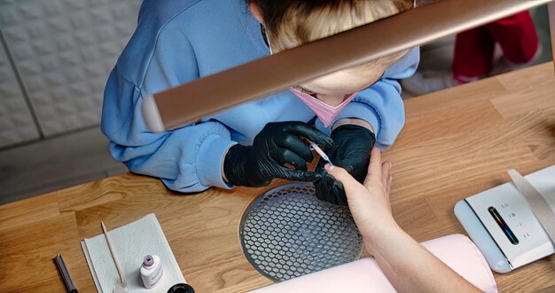 A woman getting a manicure at a nail salon.