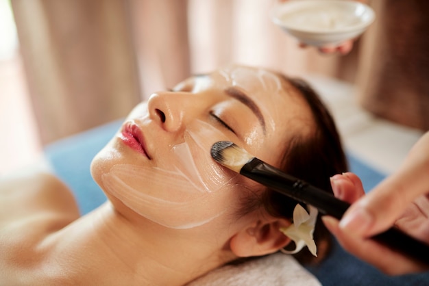 Woman getting moisturizing face treatmen