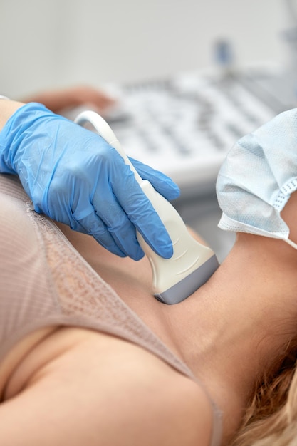 Woman getting ultrasound of a thyroid from doctor