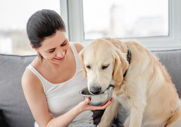 Woman giving water to cute dog