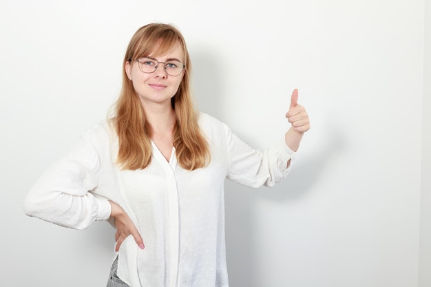 A woman in glasses and a blouse is satisfied with a white background