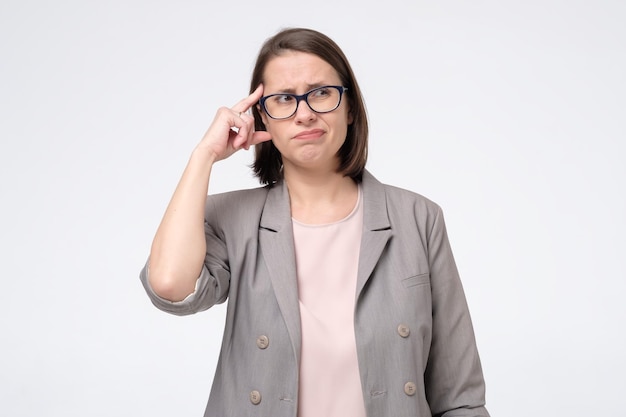 Woman in glasses looking aside with thoughtful look making plan for tomorrow