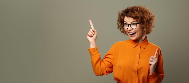 a woman in glasses and an orange shirt is pointing at something