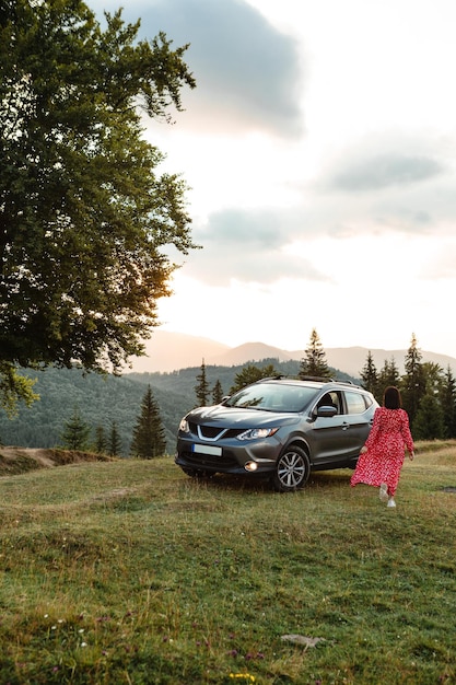 Woman goes to the car Sunset in the mountains