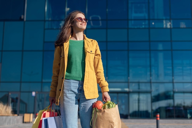 Woman goes crosswalk from a shopping mall with shopping cart with a groceries