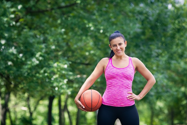 woman goes in for sports in the park with a ball