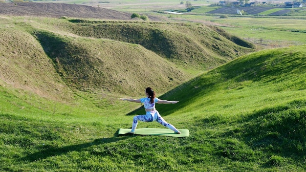 The woman goes in for sports yoga fitness in the nature in the spring in the summer on a sunny day m