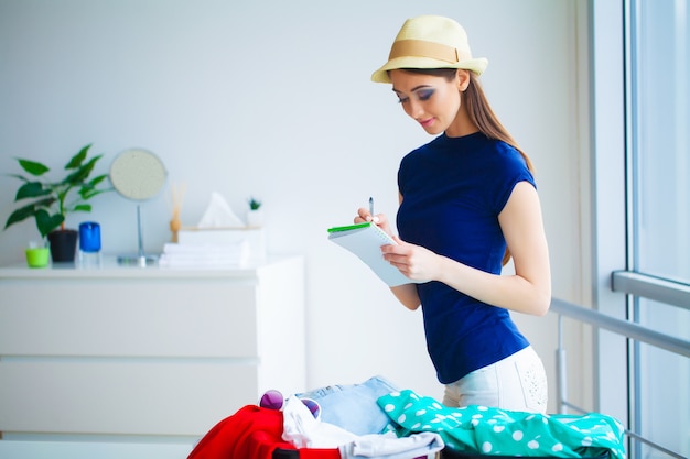 Woman goes on vacation and puts on clothes in suitcase