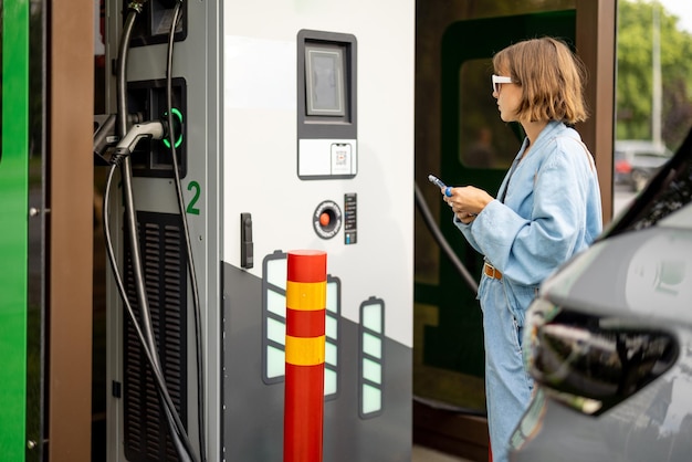 Woman going to charge electric car on public power station